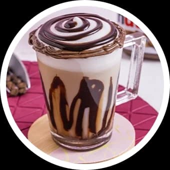 Bebida cremosa com calda de chocolate na caneca de vidro