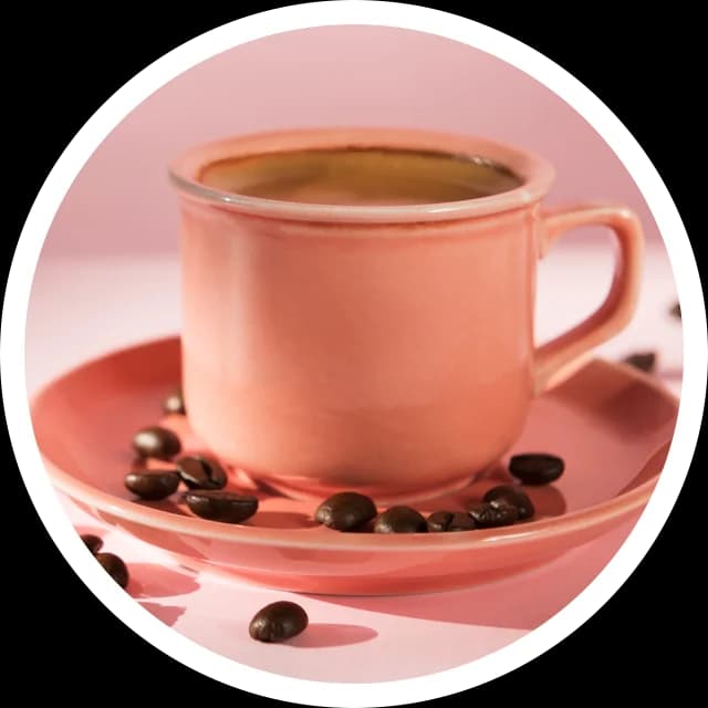 Xícara rosa de café com grãos no pires